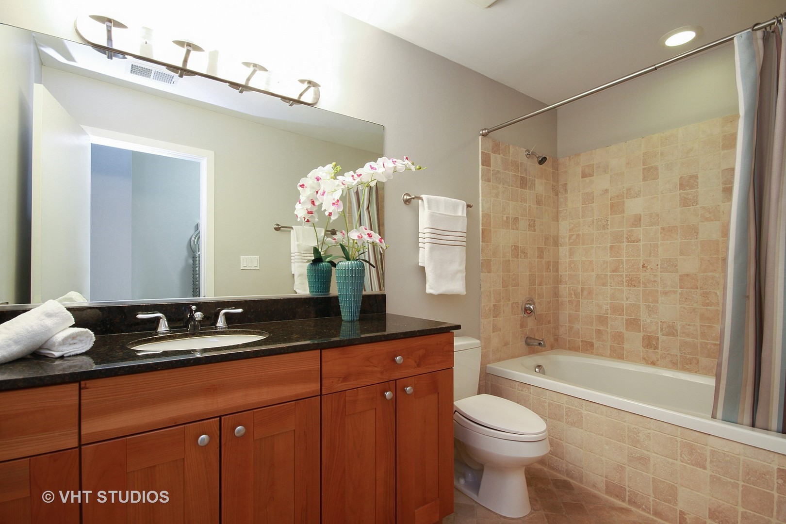 1344 West Madison Street, Unit 201 Chicago, IL 60607 - Photo 10 of 10 a bathroom with a granite countertop sink toilet and shower