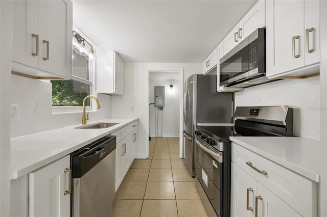 a kitchen with stainless steel appliances a stove microwave and a sink