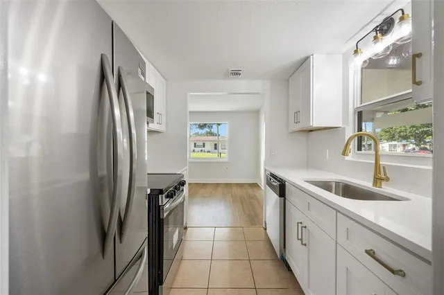 a kitchen with granite countertop a refrigerator and a sink