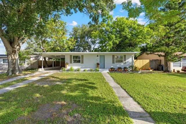 a view of a house with backyard and a tree