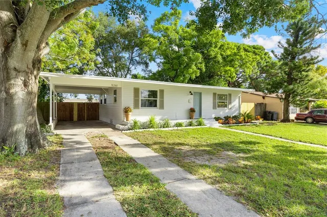 a front view of a house with a yard and potted plants