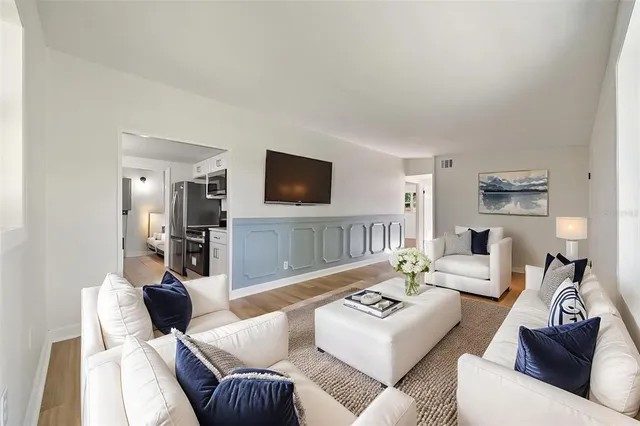 a living room with furniture a flat screen tv and a large window
