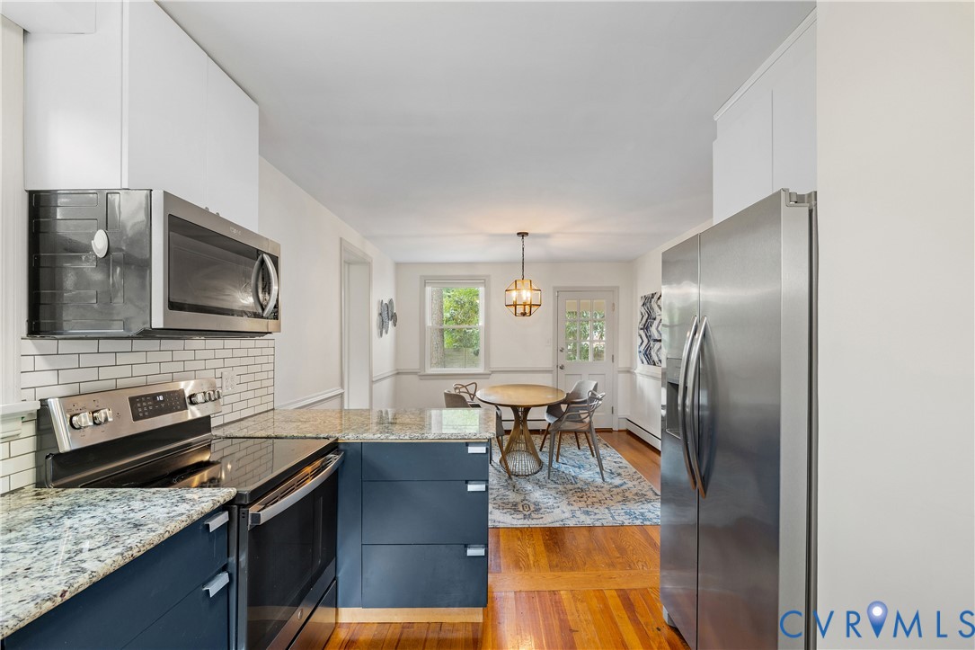 901 Bevridge Road Richmond, VA 23226 - Photo 12 of 43 a kitchen with stainless steel appliances granite countertop a refrigerator stove top oven dining table and chairs