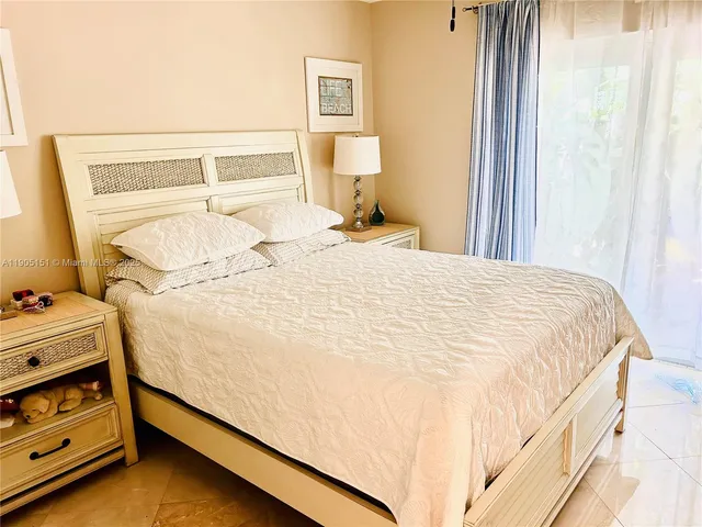 a bed sitting in a bedroom next to a window and dresser