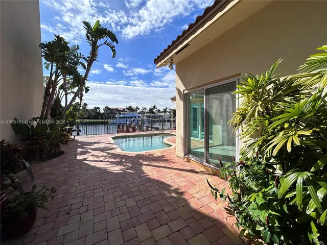 a view of a house with pool and chairs
