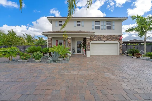 a view of a white house with potted plants and a lawn chair