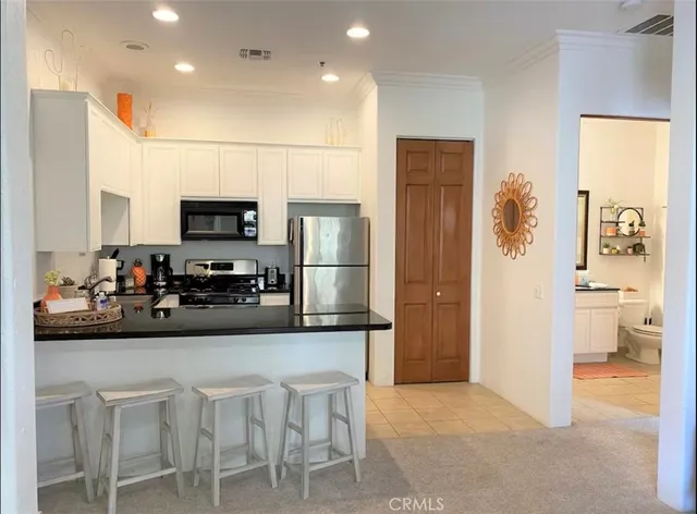 a kitchen with a refrigerator and a stove top oven