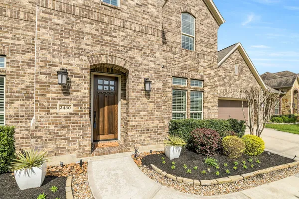 a view of a brick house with potted plants