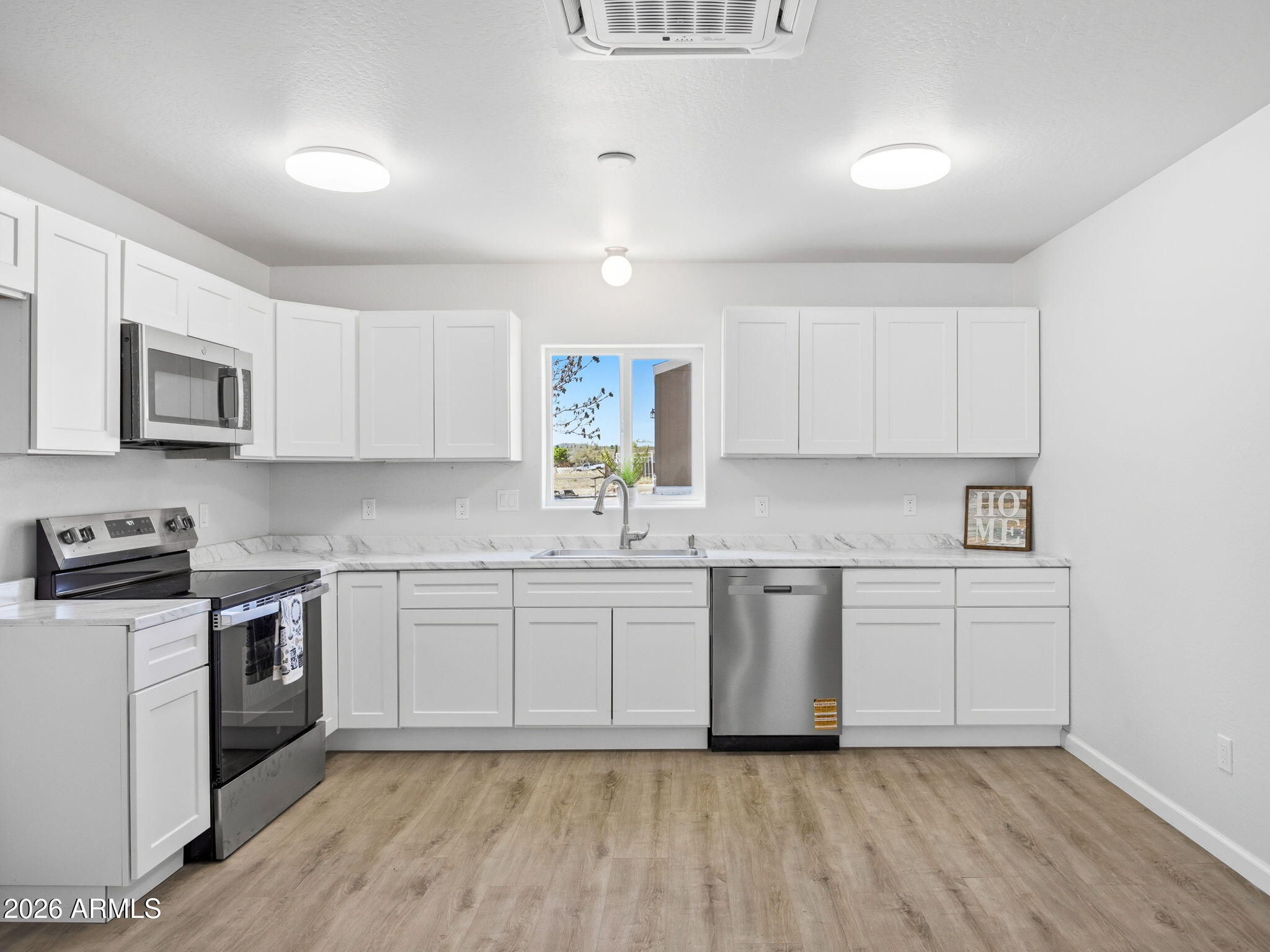 18278 Frontier Road Peeples Valley, AZ 86332 - Photo 2 of 31 a kitchen with granite countertop white cabinets and white appliances