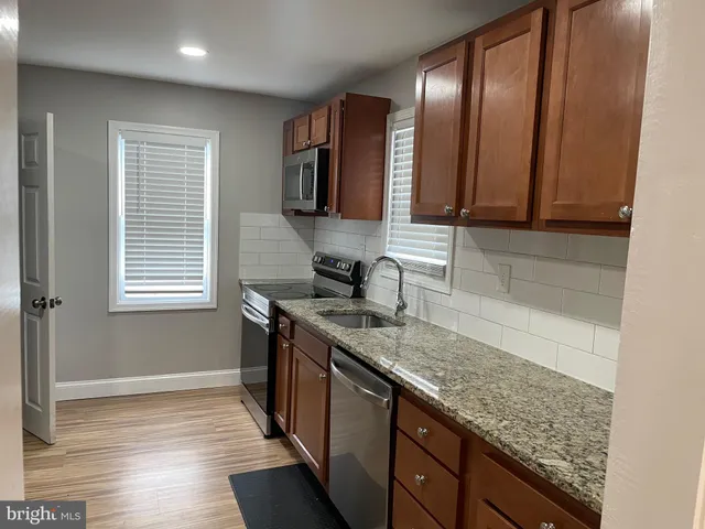 a kitchen with a sink stove and cabinets