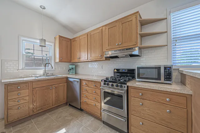 a kitchen with cabinets appliances a sink and a window
