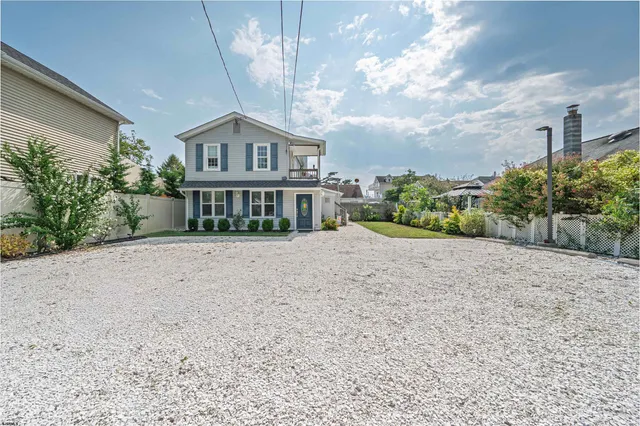 a view of house with a yard and potted plants