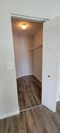 an empty room with wooden floor and closet