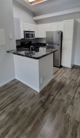a kitchen with stainless steel appliances granite countertop a sink and a stove