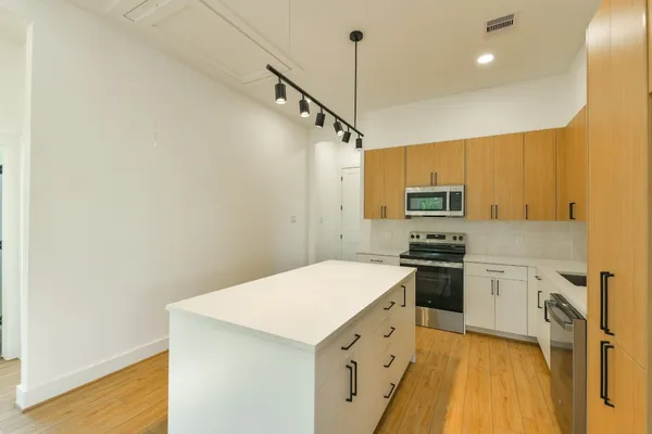 a kitchen with stainless steel appliances a stove refrigerator sink and microwave