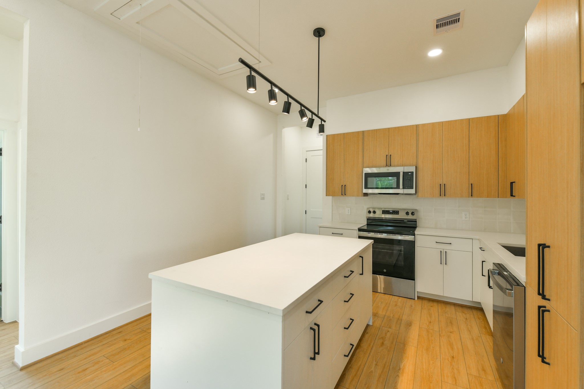 162 Wallace Street, Unit B Houston, TX 77022 - Photo 11 of 25 a kitchen with stainless steel appliances a stove refrigerator sink and microwave