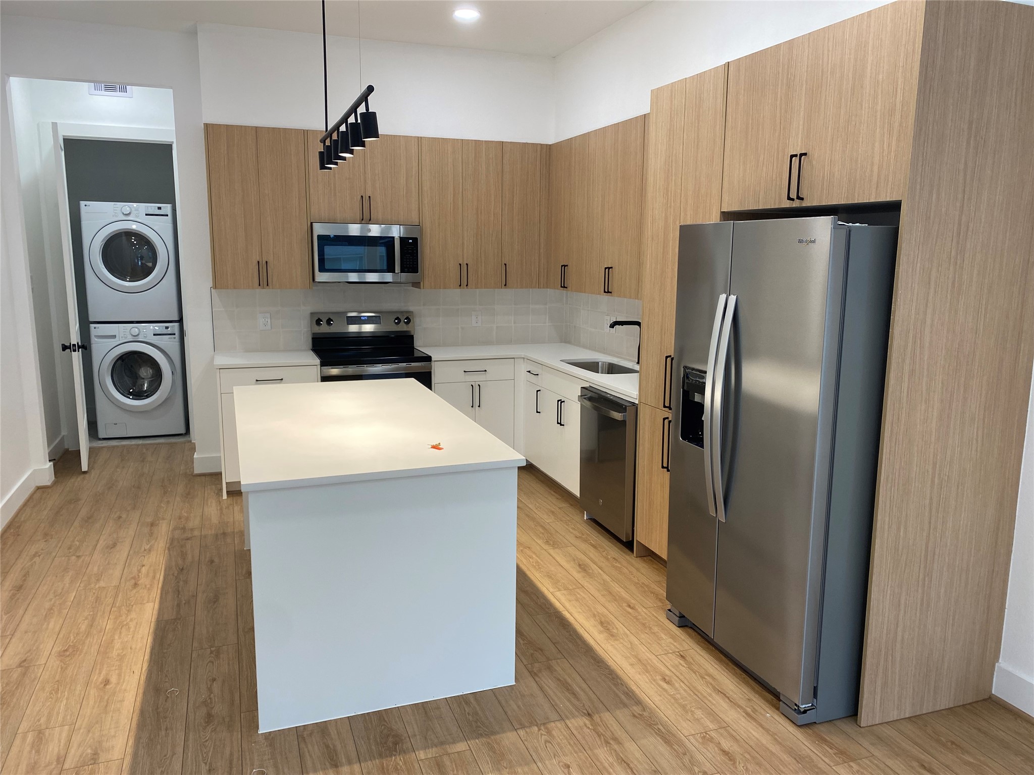 162 Wallace Street, Unit B Houston, TX 77022 - Photo 12 of 25 a kitchen with a refrigerator a stove and a wooden floor
