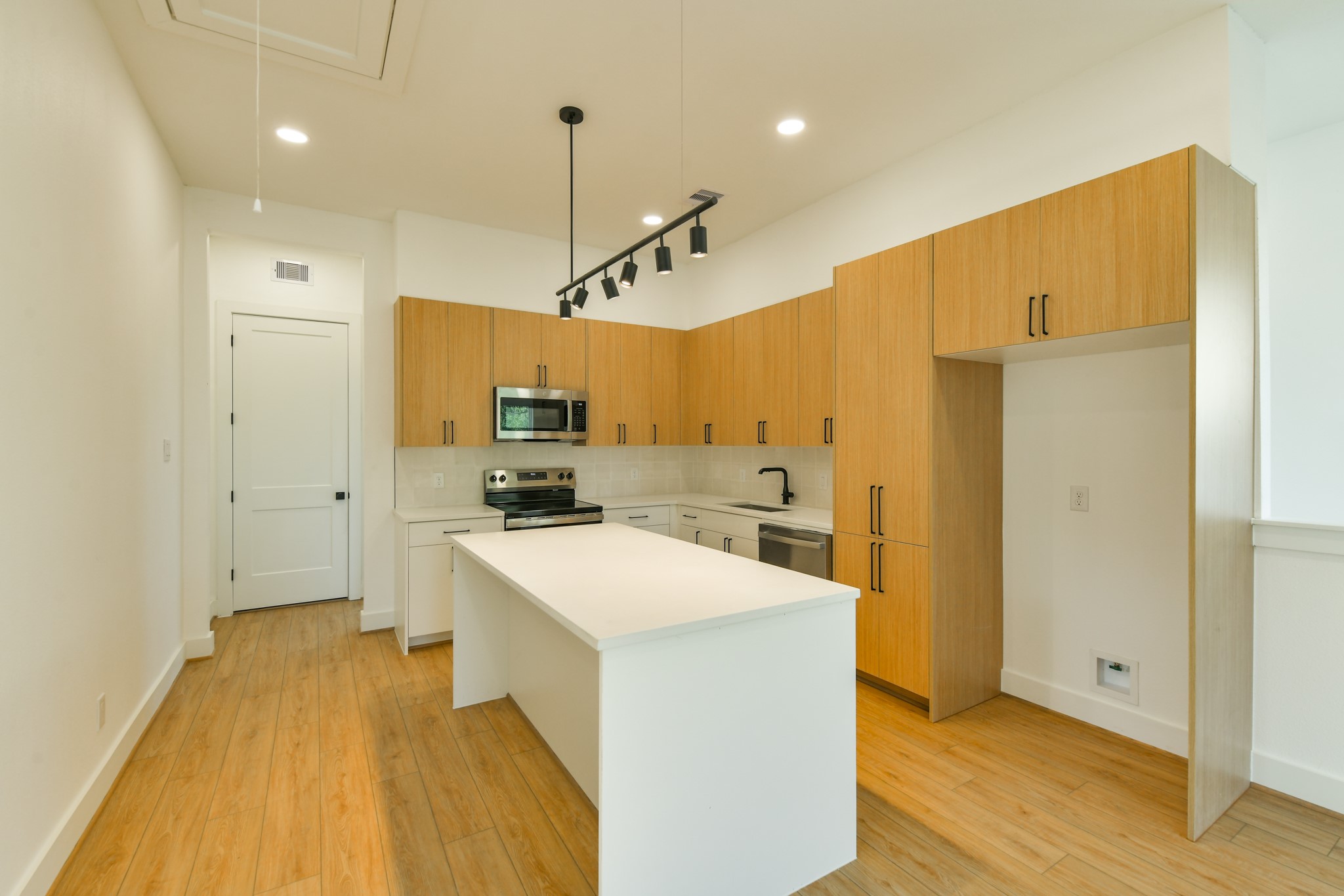 162 Wallace Street, Unit B Houston, TX 77022 - Photo 8 of 25 a large kitchen with a lot of counter space and wooden floor