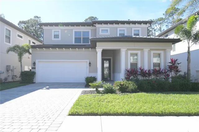 a front view of a house with a garden and plants