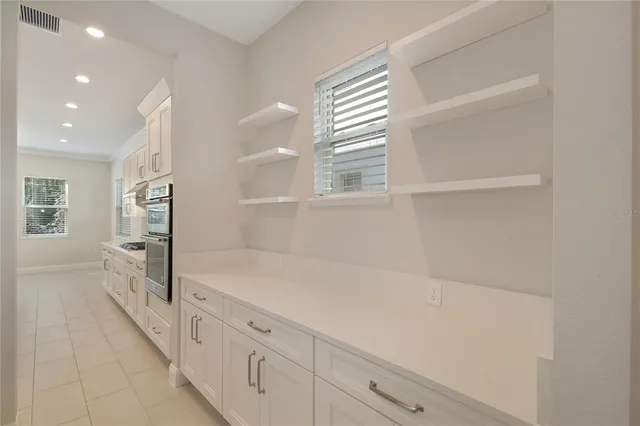 a kitchen with white cabinets and stainless steel appliances