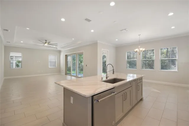 en empty room with windows and chandelier