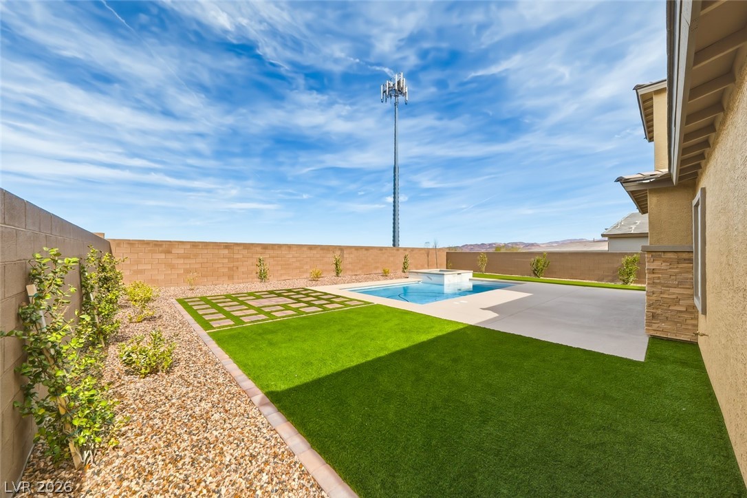 290 Rusty Ridge Lane Henderson, NV 89015 - Photo 49 of 61 Backyard w/pool & spa, desert rock w/synethic grass & pavers, built in outdoor kitchen w/fridge, cooktop & sink & No Rear Neighbors.