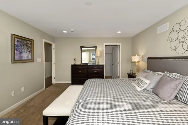 a bedroom with a large bed and a night stand