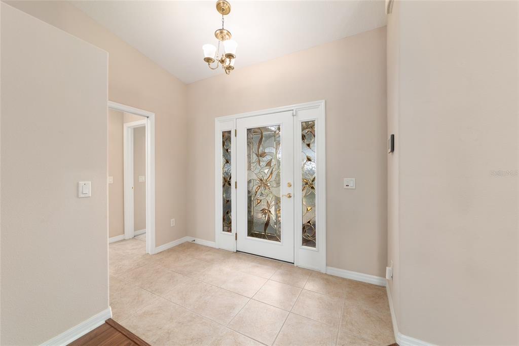 16369 Southwest 14th Avenue Road Ocala, FL 34473 - Photo 8 of 49 an empty room with chandelier fan and door