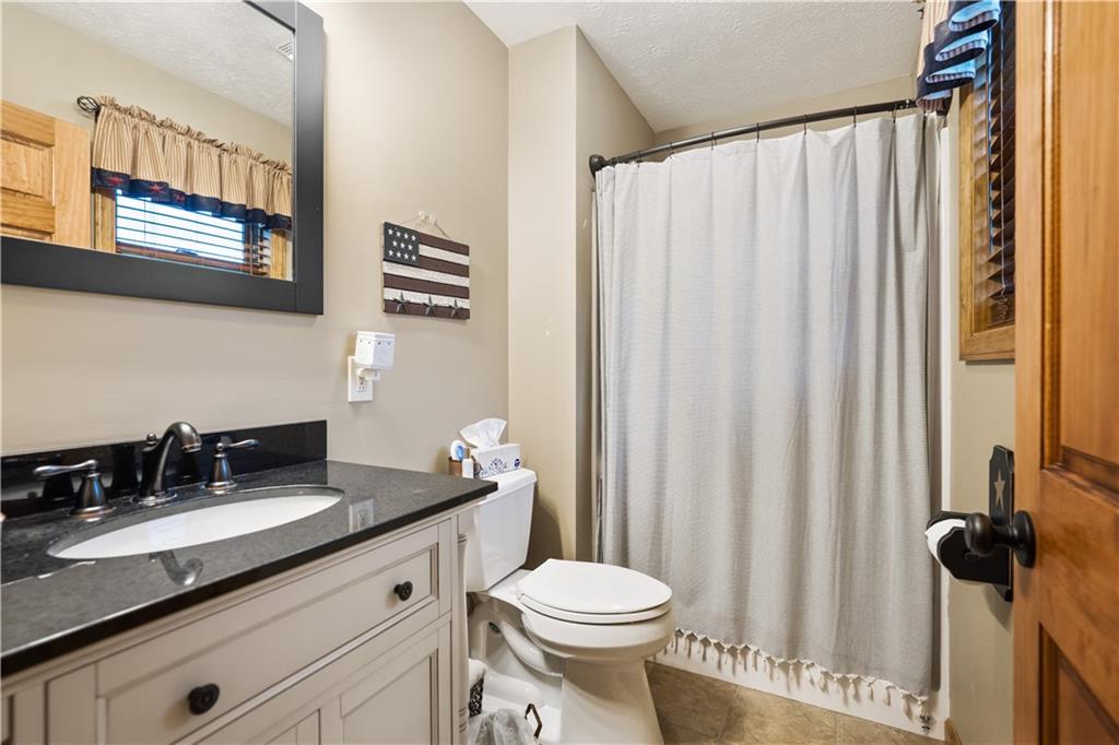 418 Shagbark Road Grindstone, PA 15442 - Photo 12 of 20 a bathroom with a granite countertop sink toilet and mirror