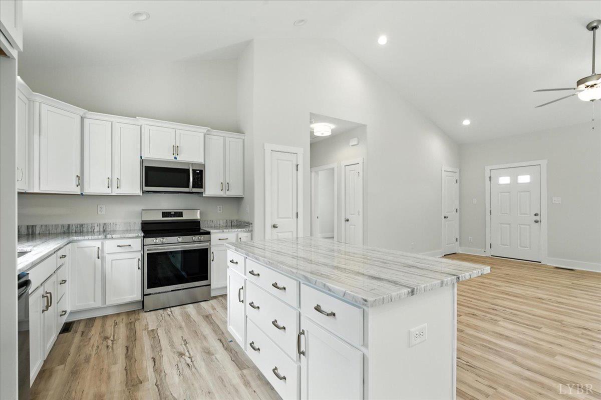 2140 Bent Creek Road Concord, VA 24538 - Photo 11 of 35 a kitchen with stainless steel appliances granite countertop a stove a sink and white cabinets