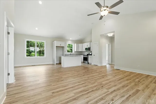 a view of empty room with wooden floor and window