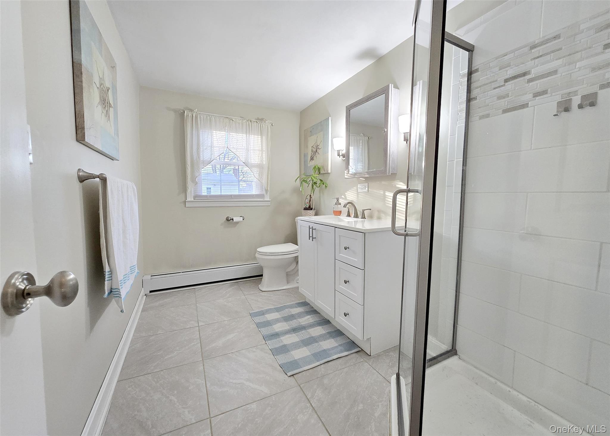 94 Clarendon Road Ronkonkoma, NY 11779 - Photo 15 of 31 a bathroom with a double vanity sink toilet mirror and shower