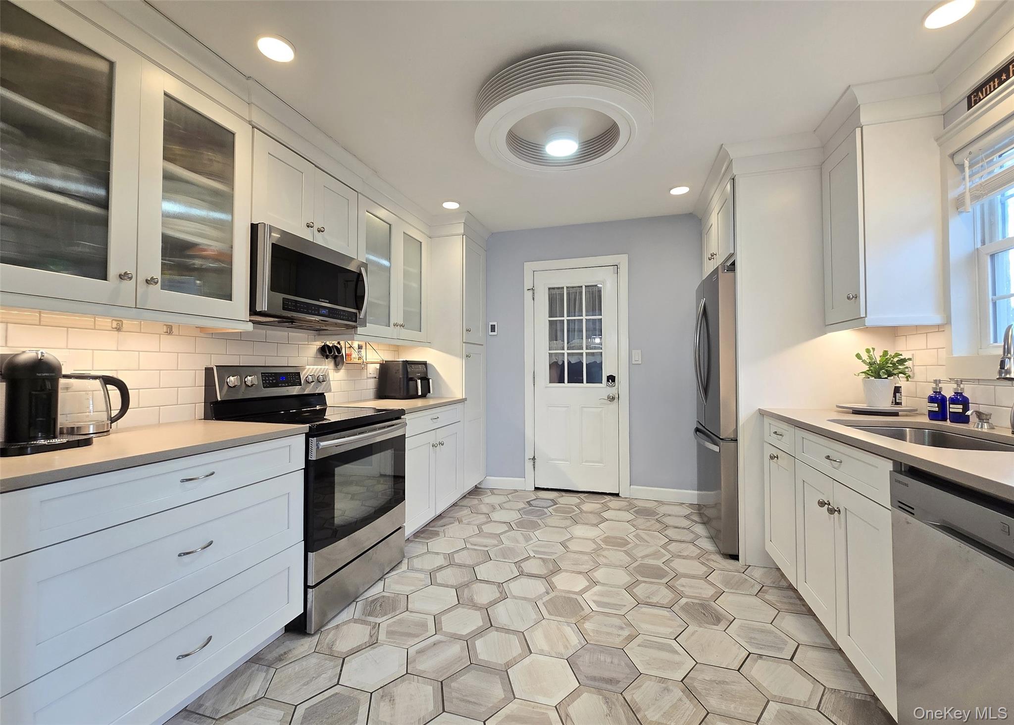 94 Clarendon Road Ronkonkoma, NY 11779 - Photo 7 of 31 a kitchen with granite countertop a sink stainless steel appliances and cabinets