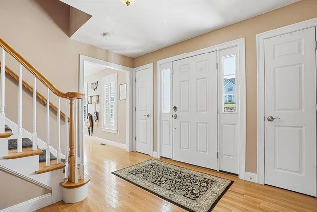 a view of entryway with wooden floor and front door