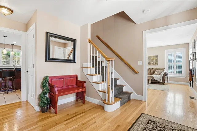 a living room with furniture and a dining table with wooden floor