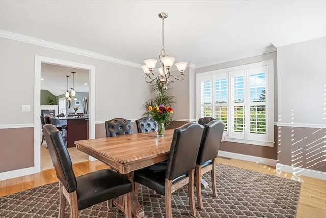 a dining room with furniture a large window and wooden floor