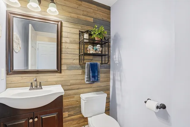 a bathroom with a toilet a sink and mirror