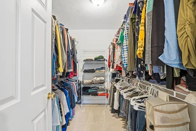 a view of walk in closet with clothes and shoes