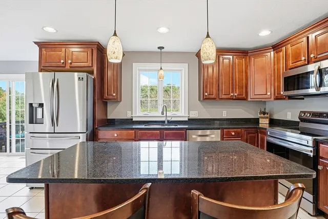 a kitchen with stainless steel appliances granite countertop a sink a stove and a microwave