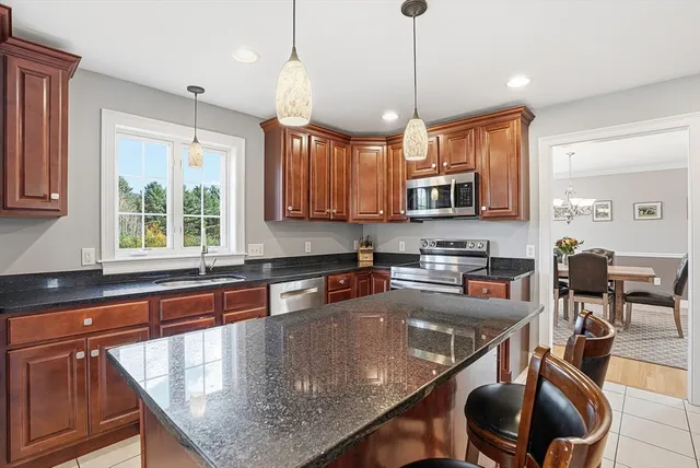 a kitchen with stainless steel appliances granite countertop a stove a sink island and a refrigerator