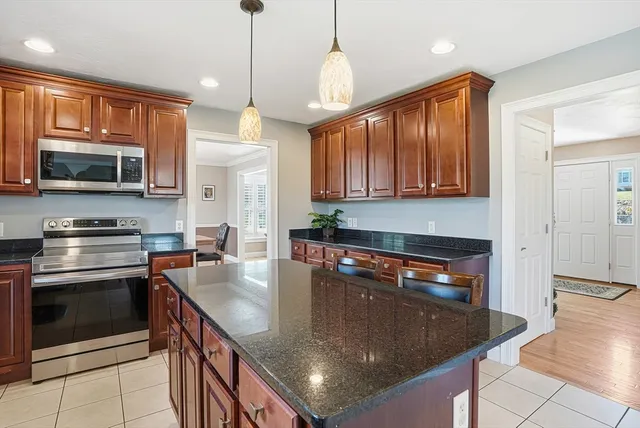 a kitchen with stainless steel appliances granite countertop a sink a stove and a microwave