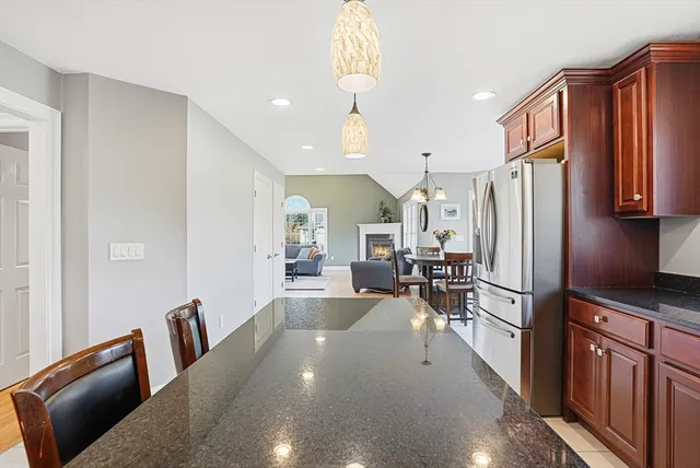 a kitchen with stainless steel appliances a refrigerator a stove a dining table and chairs