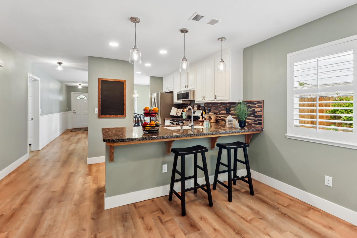 567 I Street Lincoln, CA 95648 - Photo 11 of 53 a kitchen with kitchen island granite countertop a table chairs sink and microwave