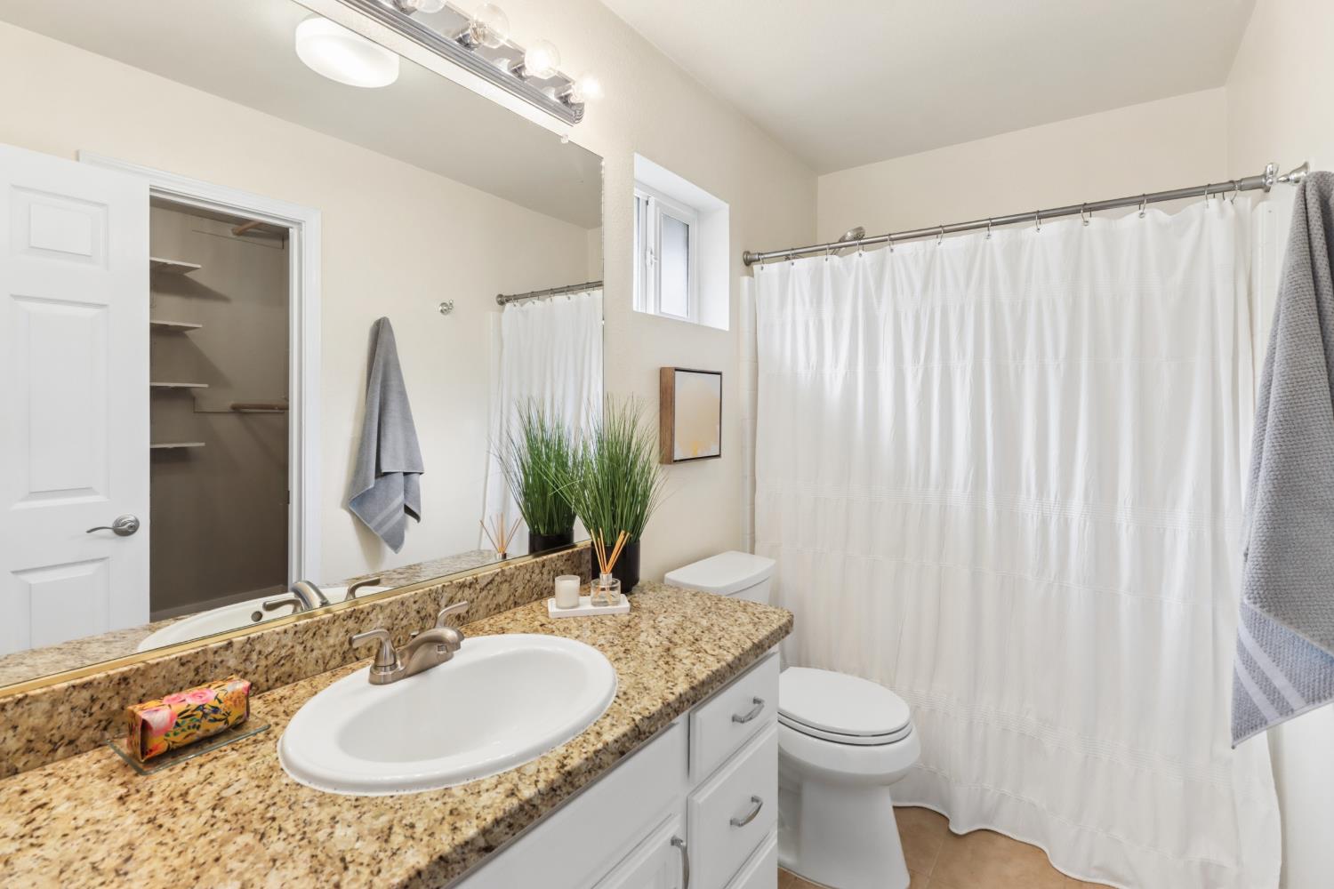 567 I Street Lincoln, CA 95648 - Photo 25 of 53 a bathroom with a granite countertop sink toilet and mirror