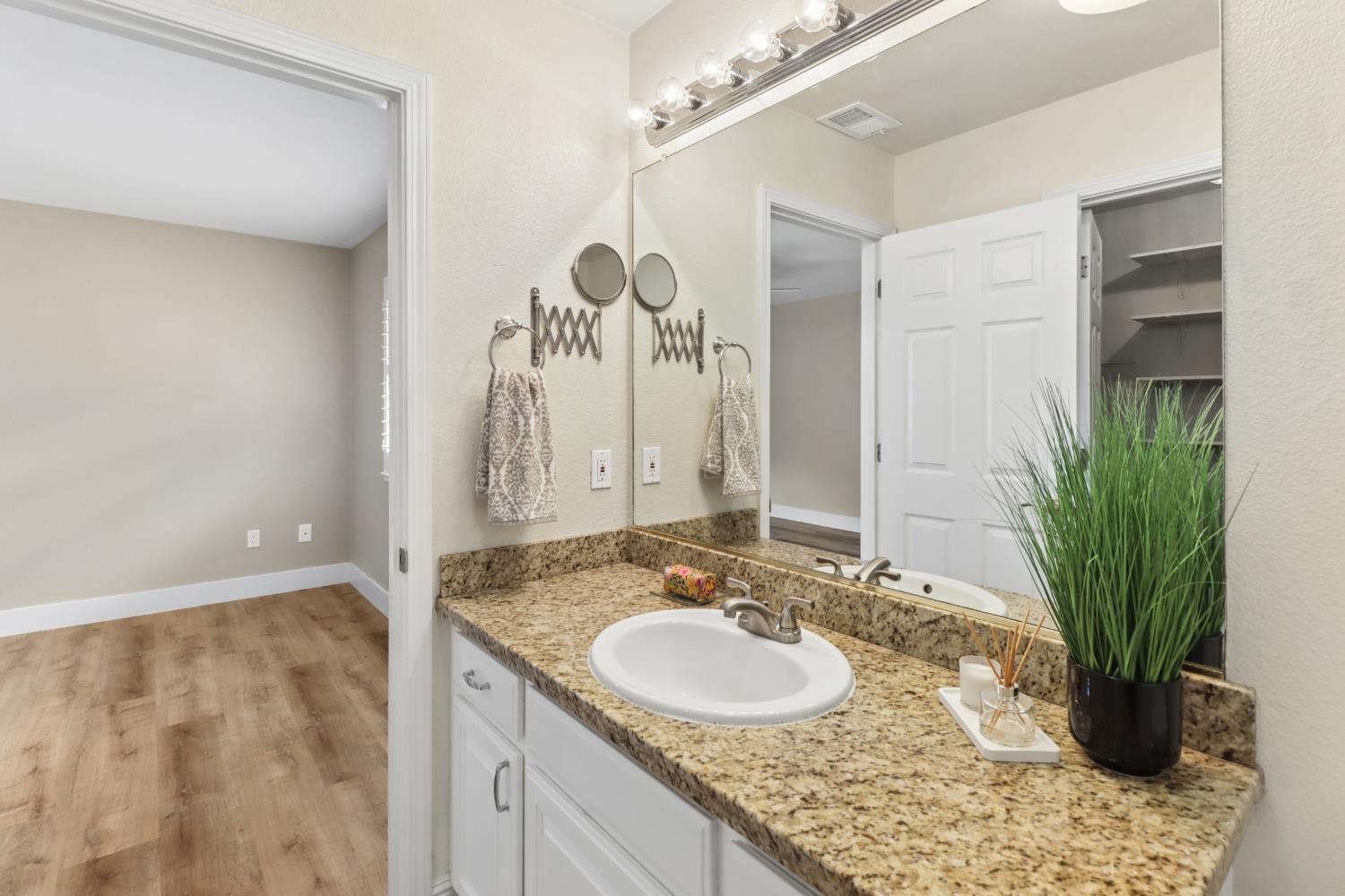 567 I Street Lincoln, CA 95648 - Photo 26 of 53 a bathroom with a granite countertop sink a large mirror and a shower