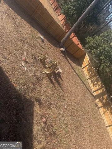 a view of a yard with wooden fence