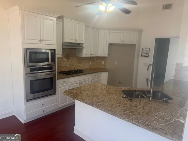 a kitchen with granite countertop a stove and a refrigerator