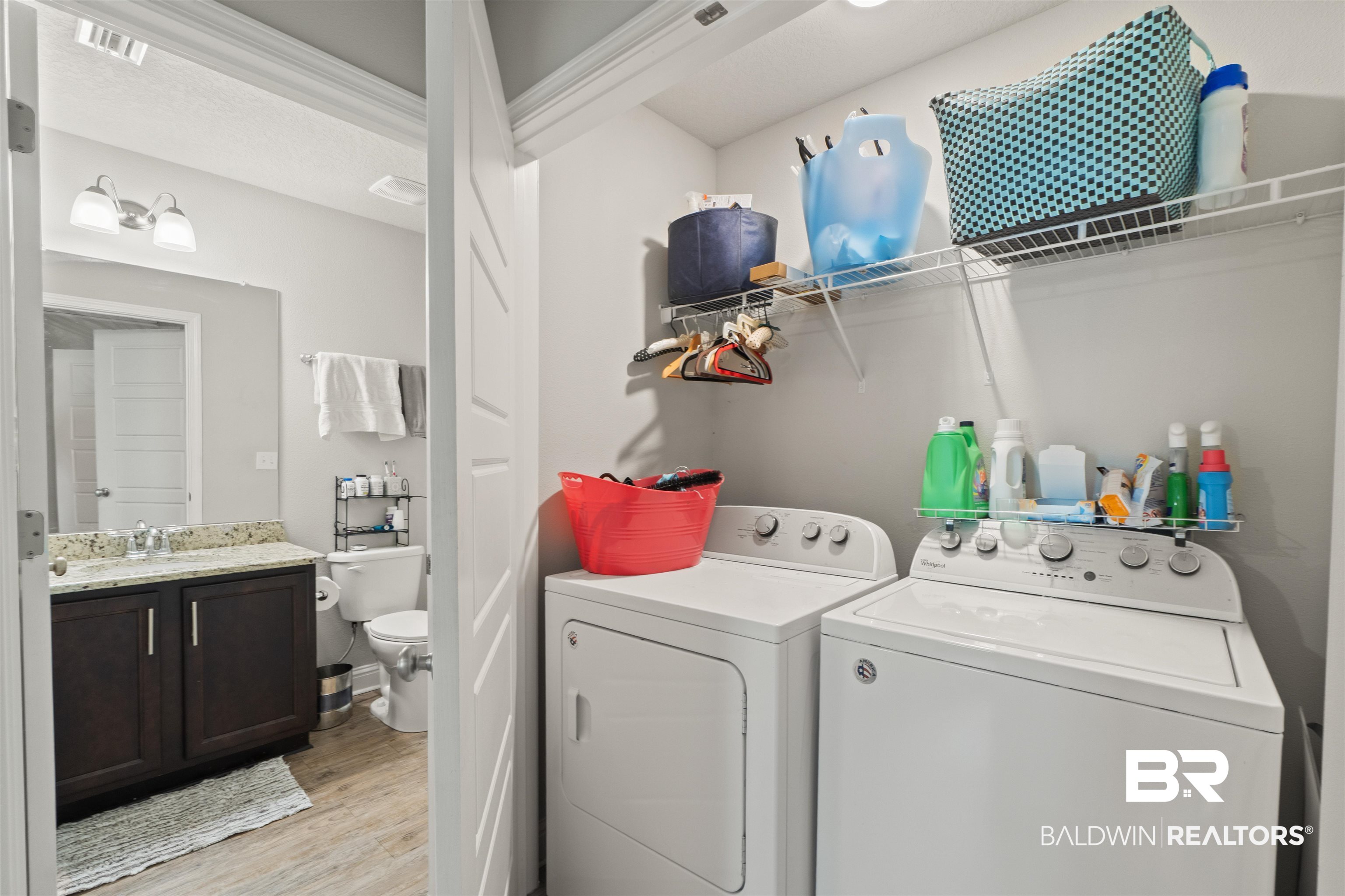 25806 Pollard Road, Unit 6 Daphne, AL 36526 - Photo 21 of 38 Dedicated laundry area featuring a white washer and dryer, complemented by overhead wire shelving