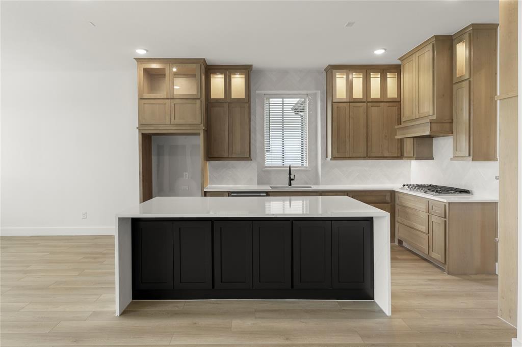 981 Georgetown Place Prosper, TX 75078 - Photo 9 of 30 a kitchen with a sink and cabinets