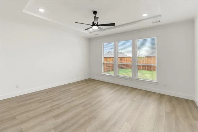 a view of a kitchen with wooden floor and a ceiling fan
